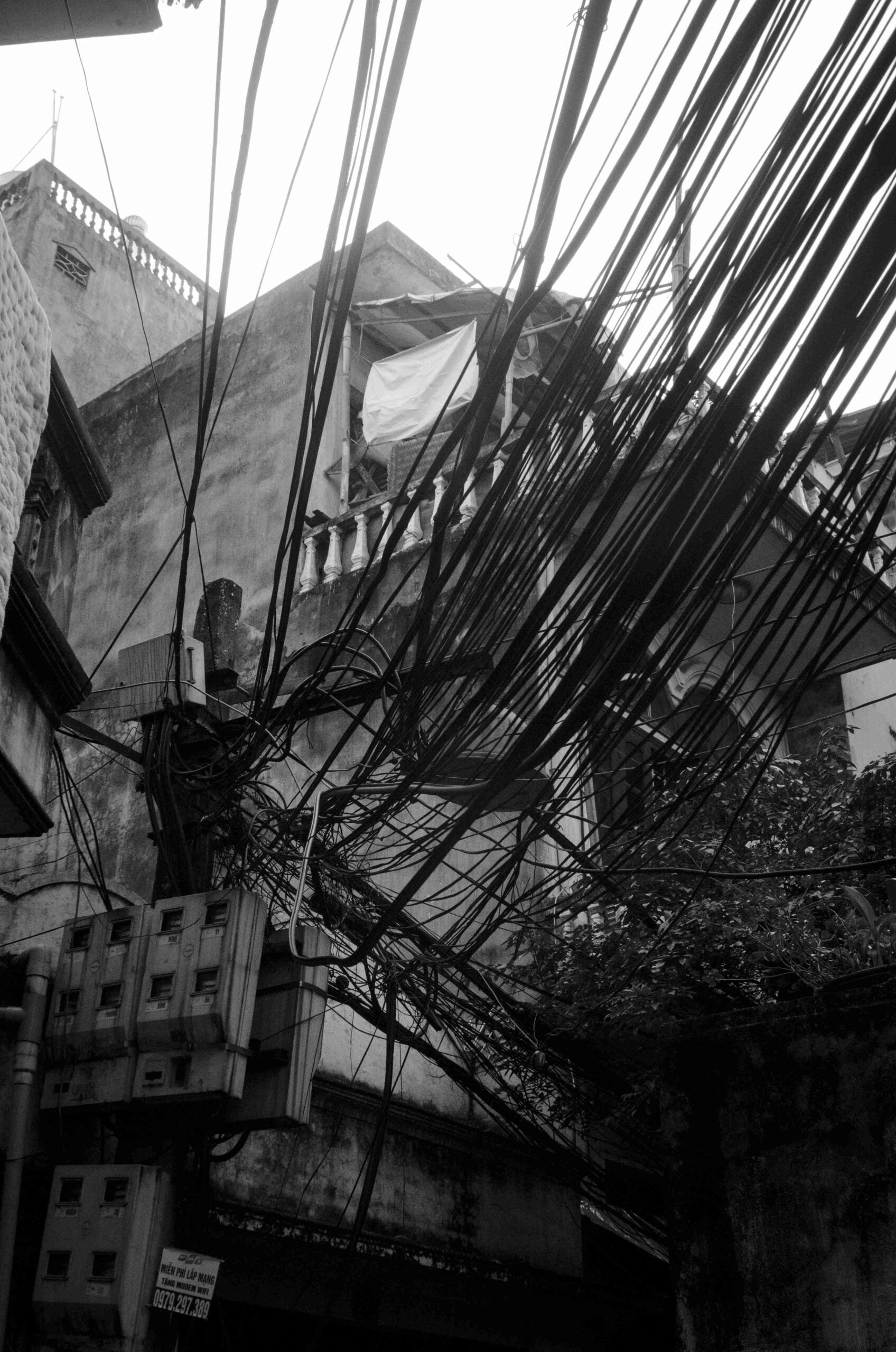 Amas spectaculaire de câbles noirs entremêlés sur un poteau.