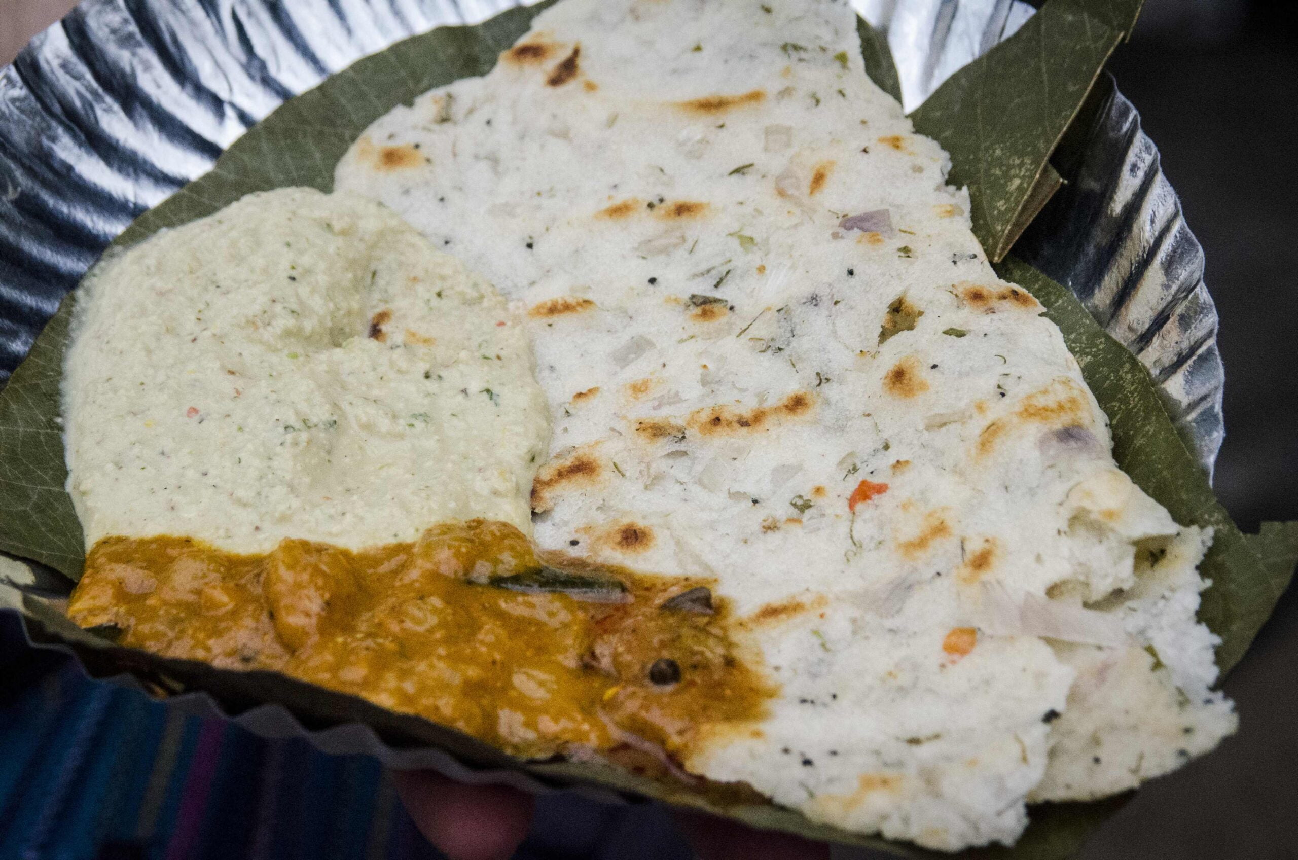 Pain plat indien feuilleté et garni, servi sur une feuille de bananier.