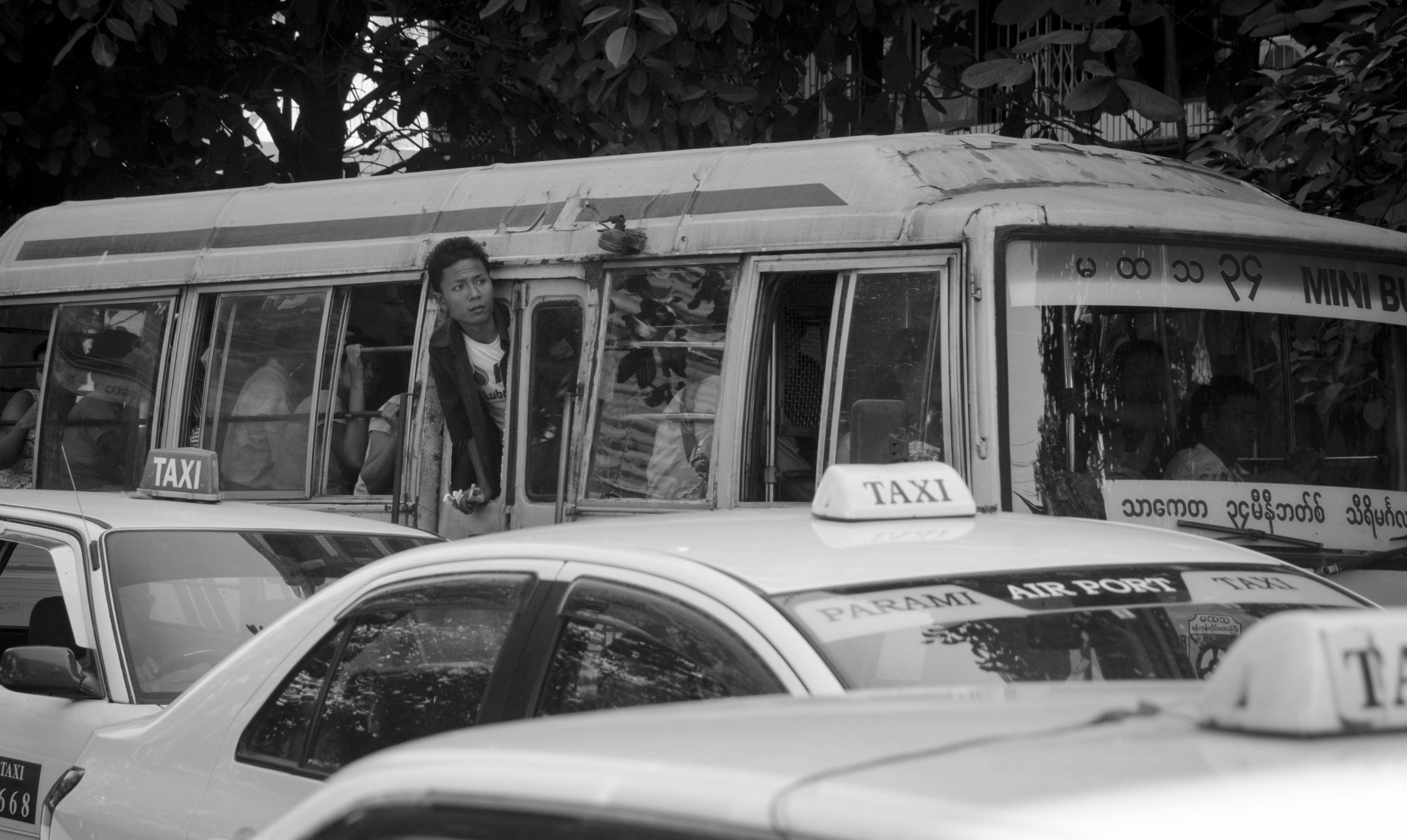 Vieux autobus colorés bondés de passagers roulant dans la ville.