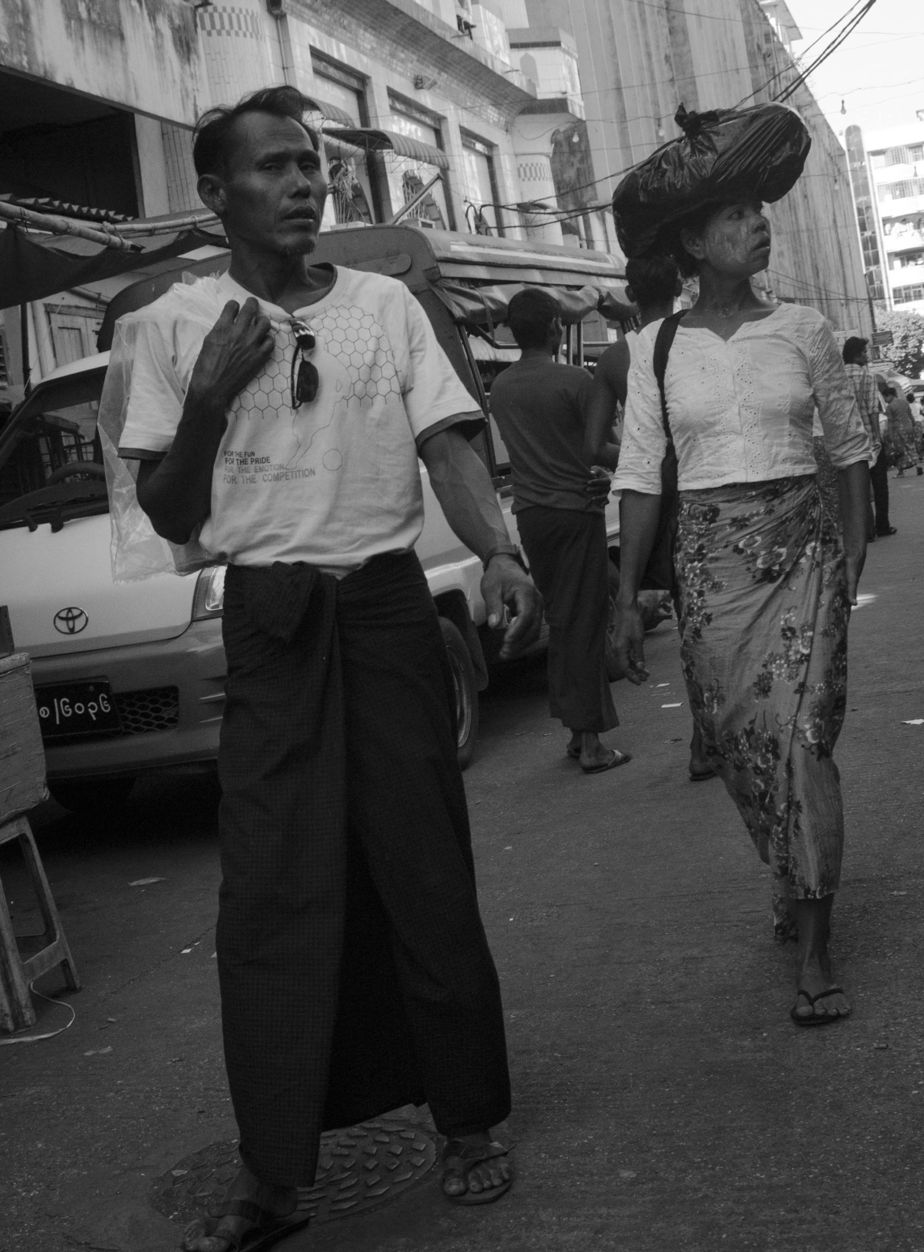 Homme et femme birmans marchant ou posant ensemble à l'extérieur.