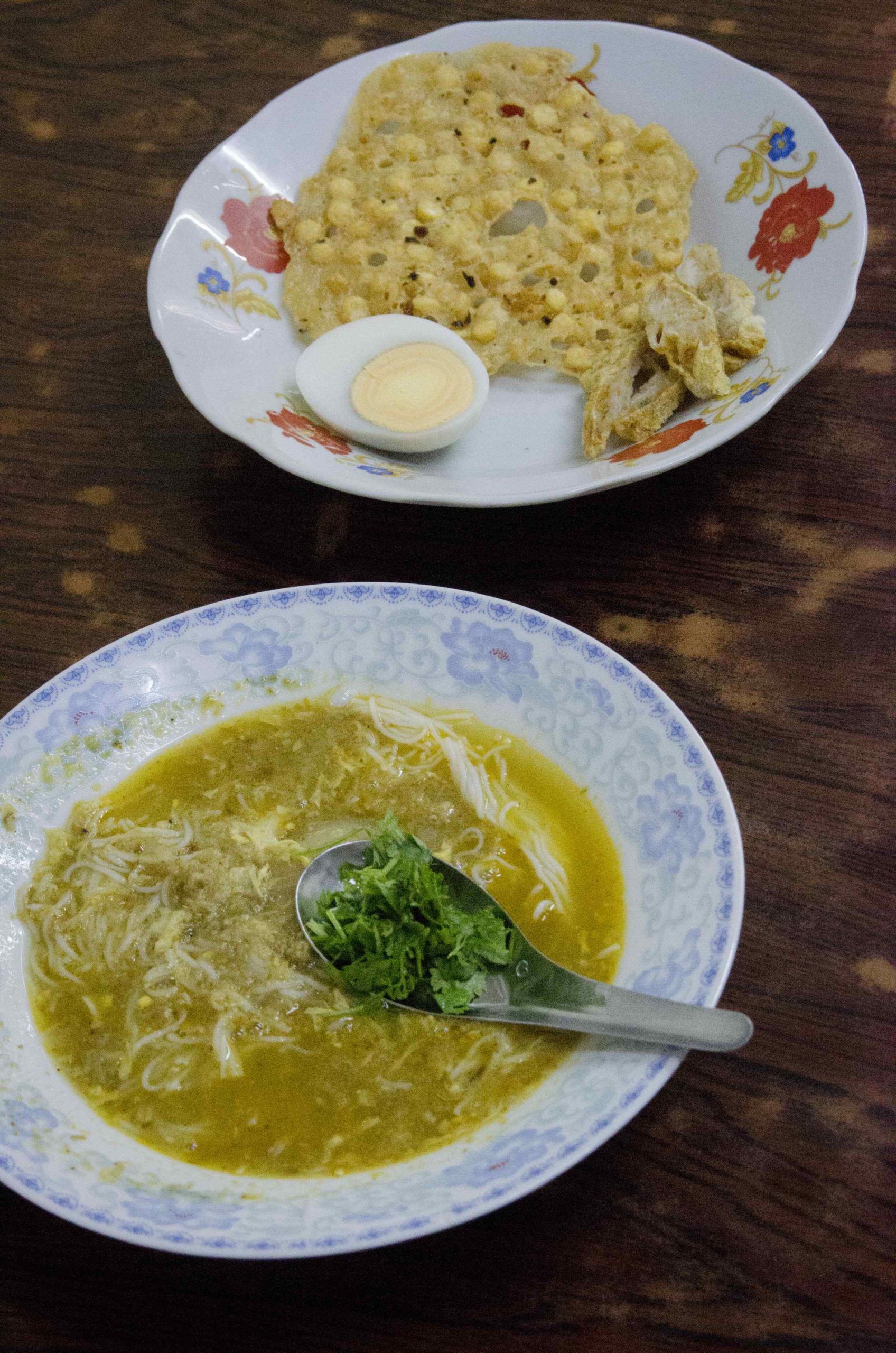 Bouillon épais aux nouilles de riz garni de poisson et d'herbes.