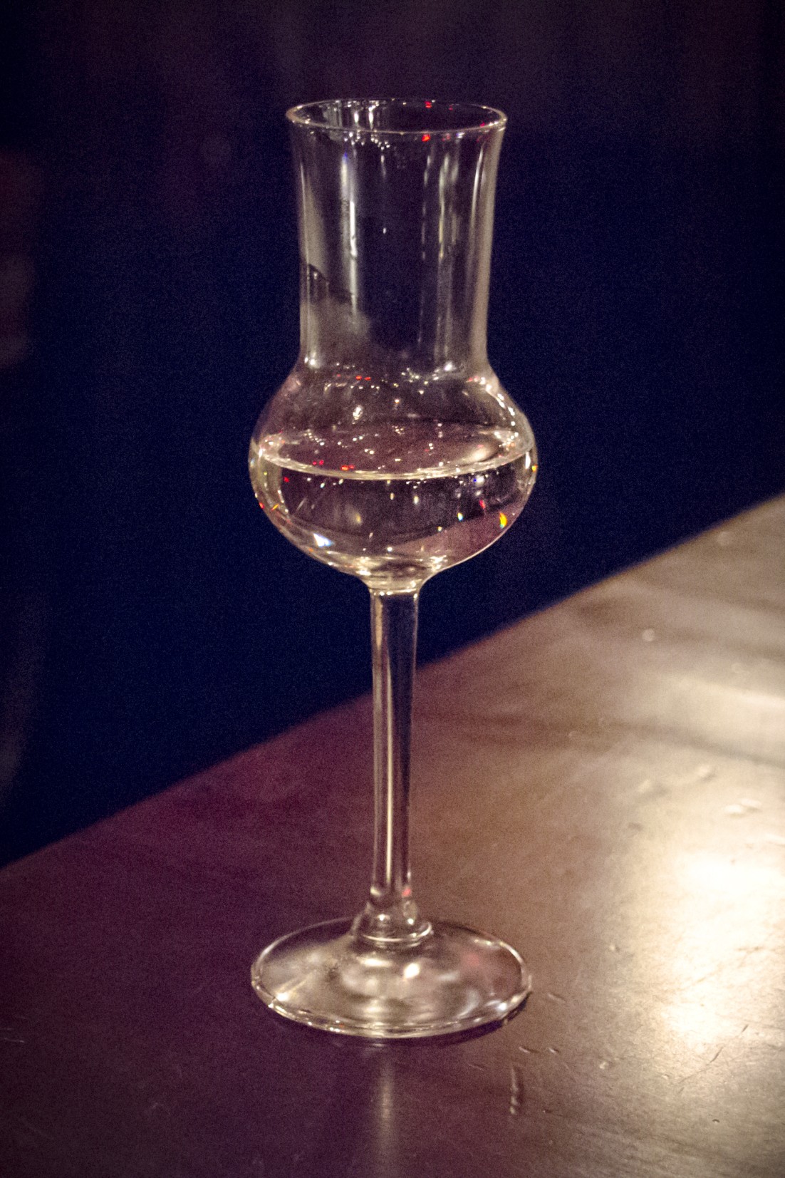 Un verre de bière blonde servi à côté d'un petit verre de genièvre.