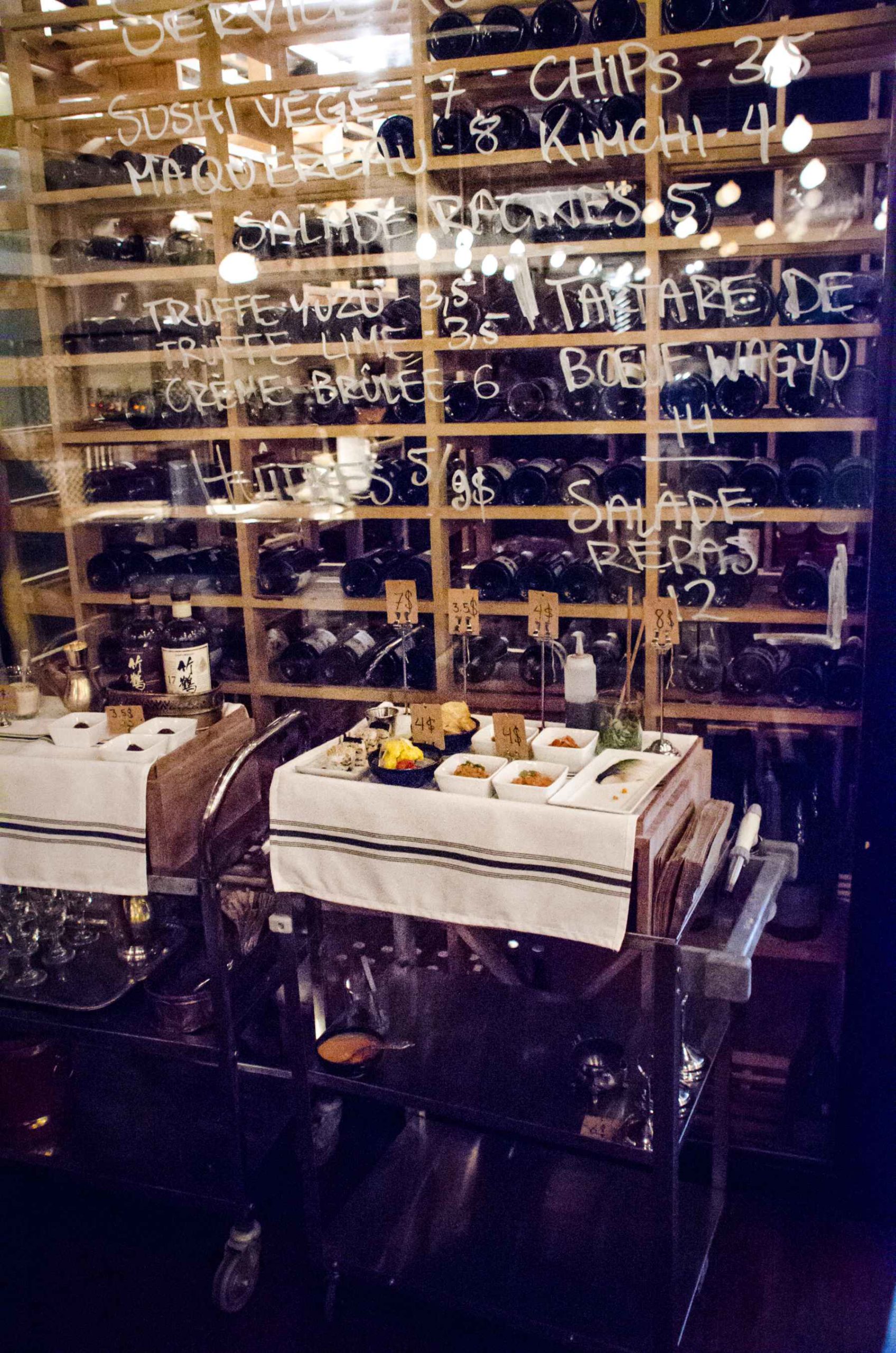 Espace de stockage mural contenant des centaines de bouteilles de vin.