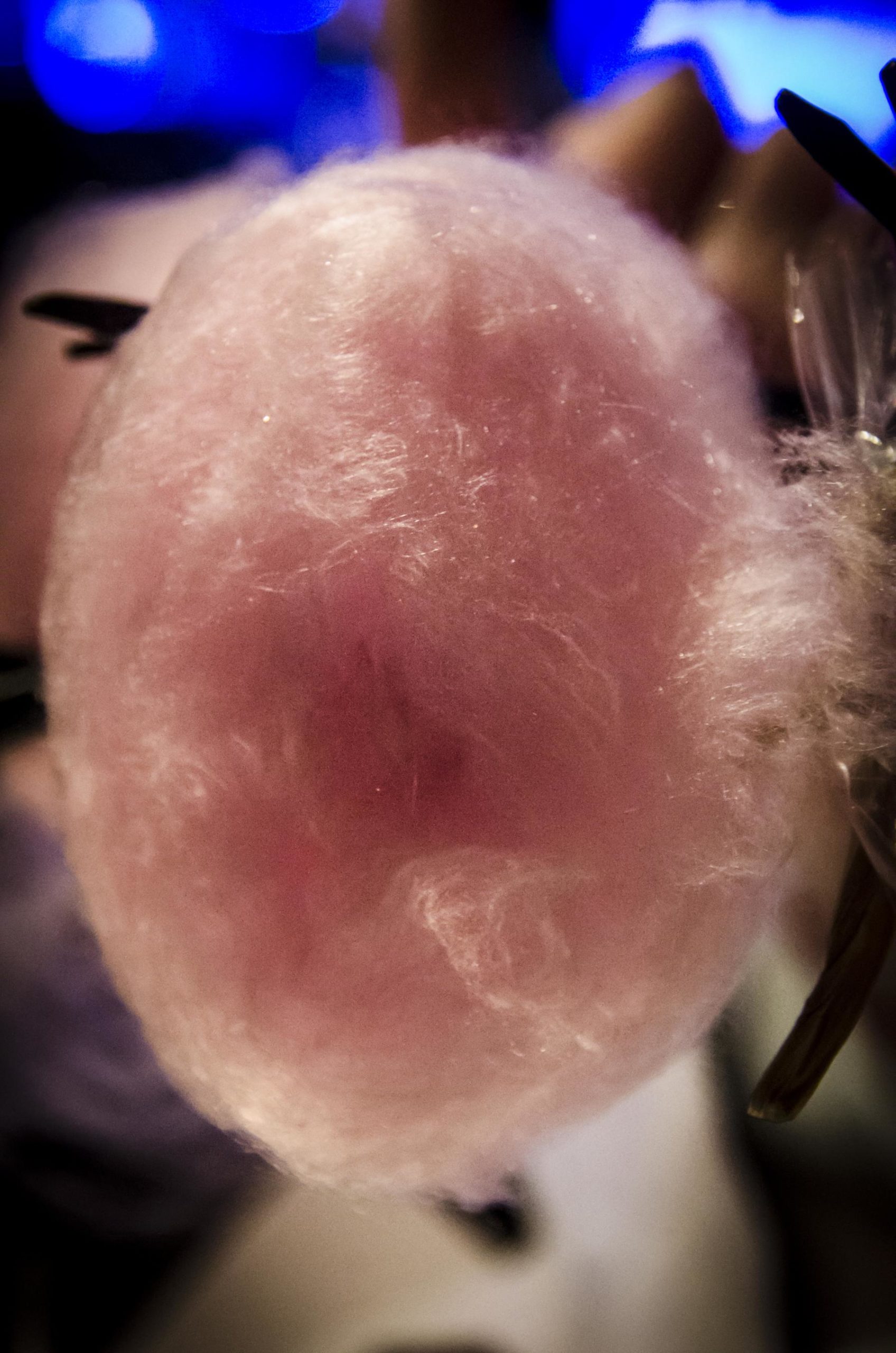 Nuage cotonneux de sucre filé de couleur vive déposé dans une assiette.
