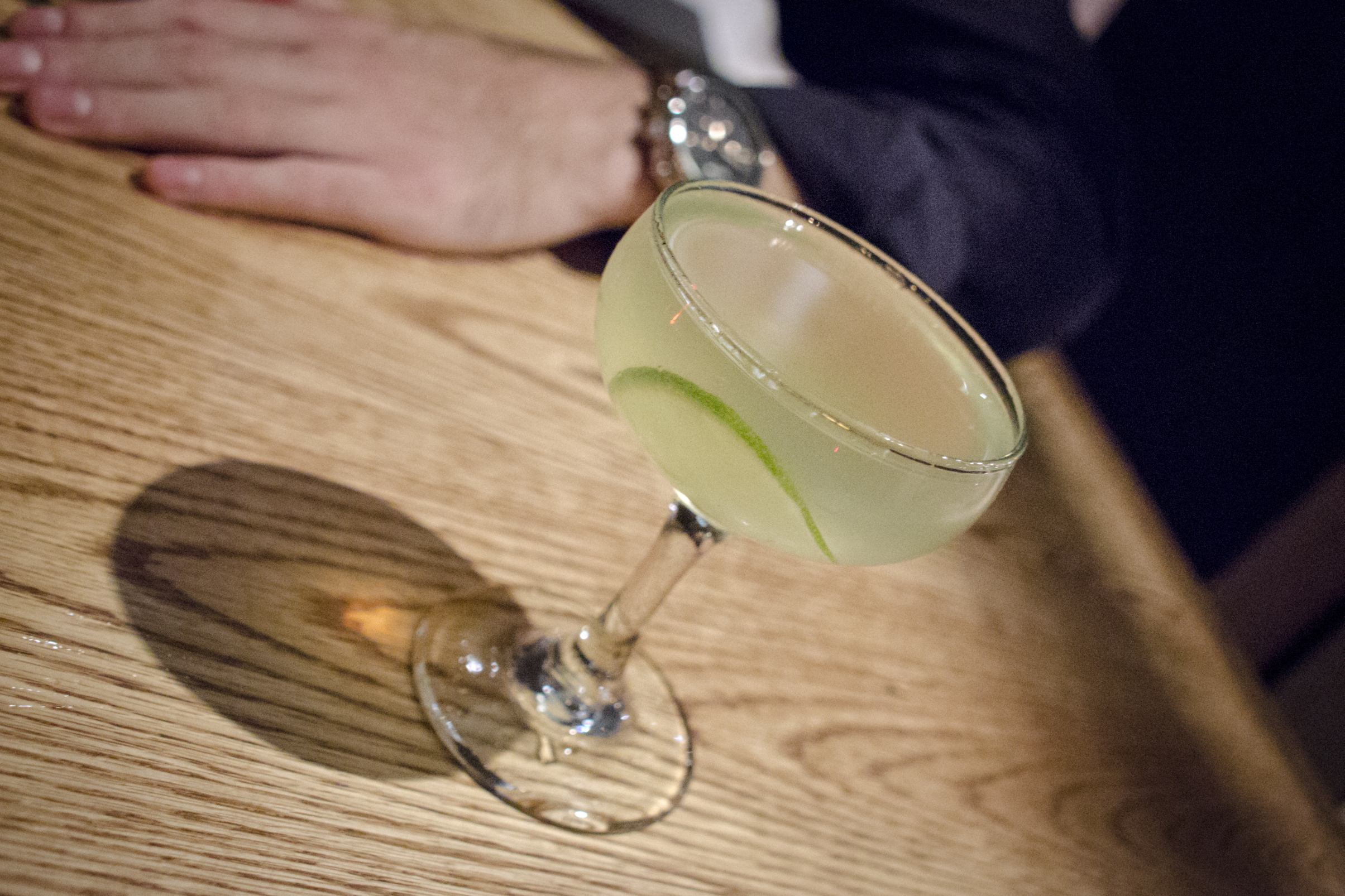 Cocktail translucide servi sans glace dans une élégante coupe triangulaire.