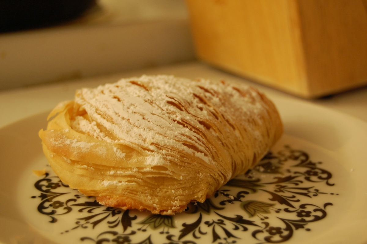 A baked sfogliatelle pastry resting on a plate