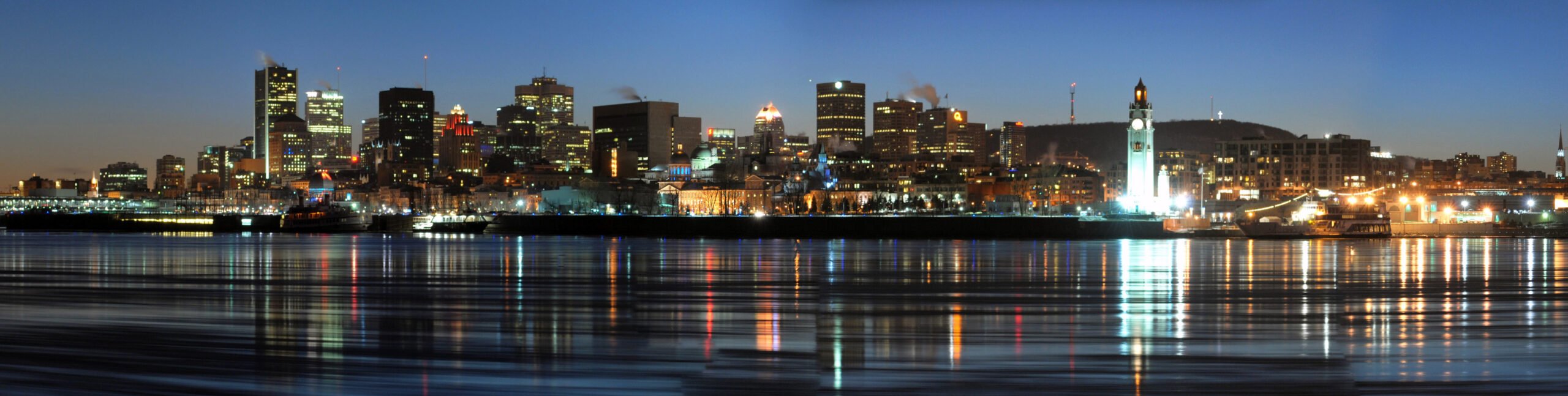 The skyline towers and buildings over the water at night in Montreal