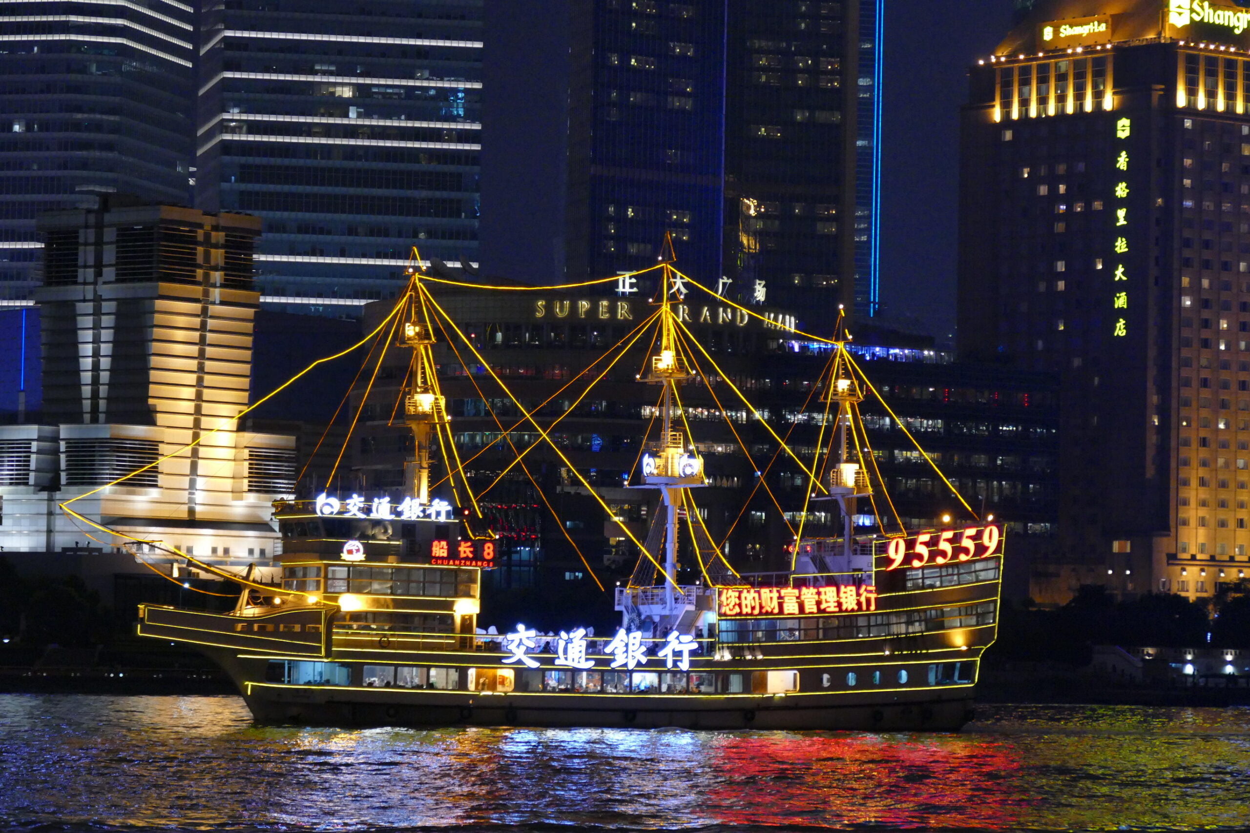 Ship illuminated on the water at night in Shanghai