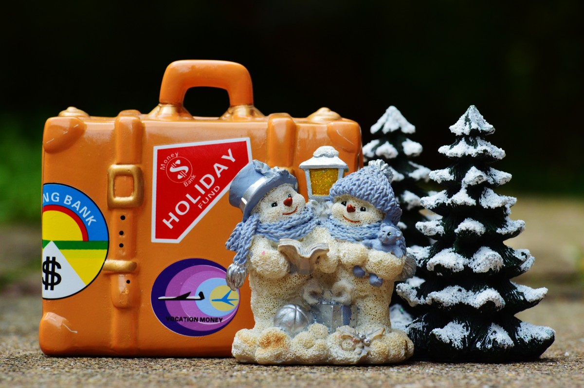 Travel luggage and a snowman figure in the snow