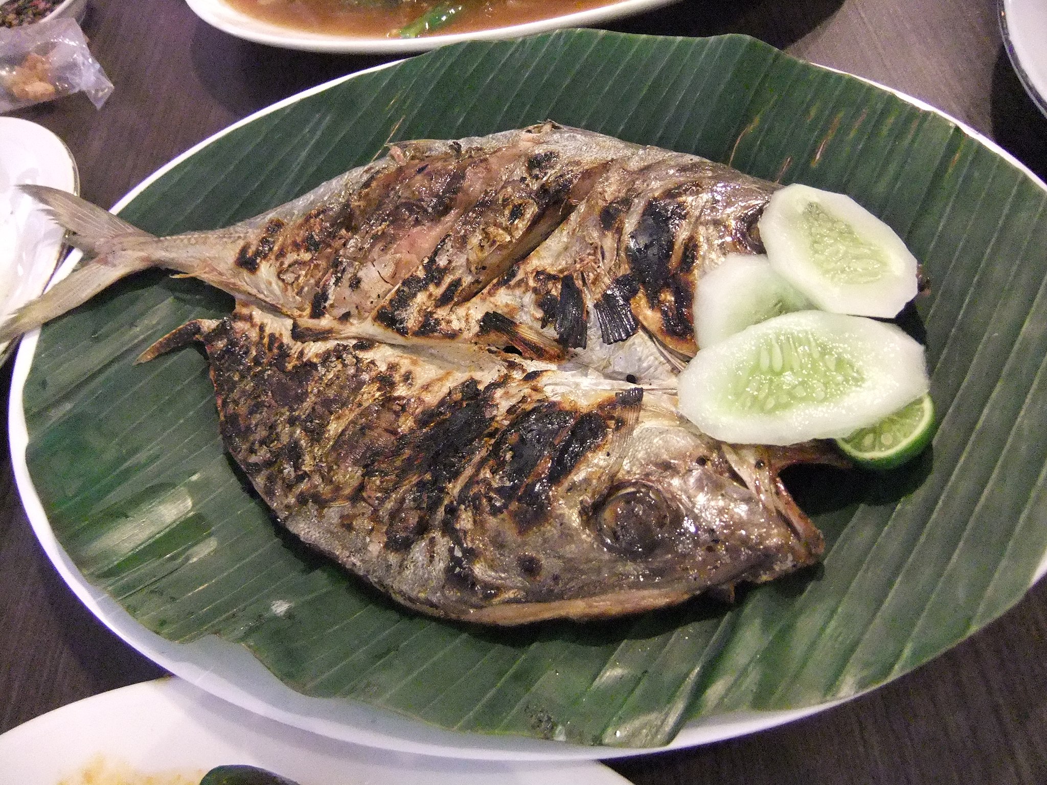 Grilled fish garnished with cucumber slices